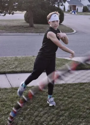 SpeedyPetey throwing the football while wearing the SPEEDY performance sports headband in white and SPEEDY sleeveless tee-shirt in black