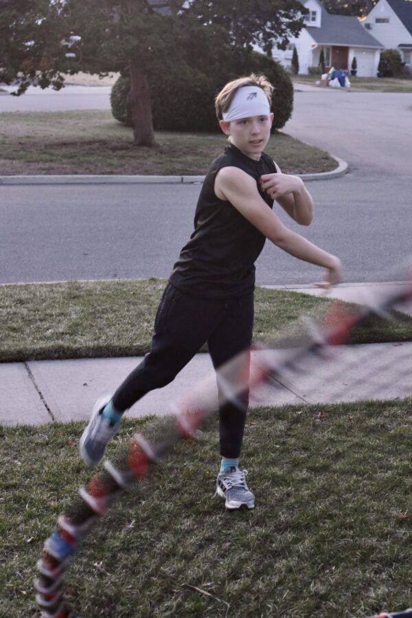 SpeedyPetey throwing the football while wearing the SPEEDY performance sports headband in white and SPEEDY sleeveless tee-shirt in black