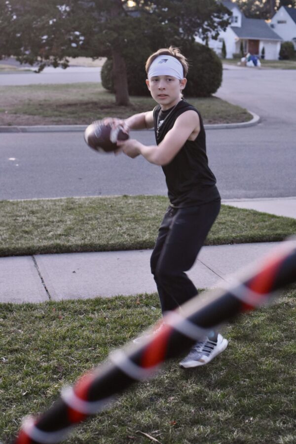SpeedyPetey throwing the football while wearing the SPEEDY performance sports headband in white and SPEEDY sleeveless tee-shirt in black