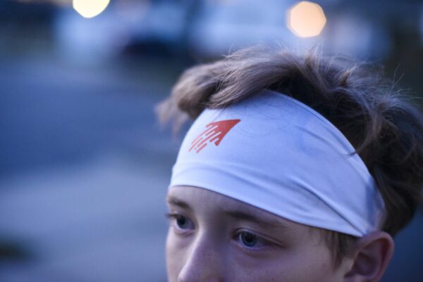 Speedy performance sports headband in white with orange icon