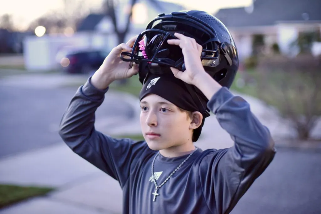SpeedyPetey with the SPEEDY Performance Sport Beanie as he puts on his football helmet