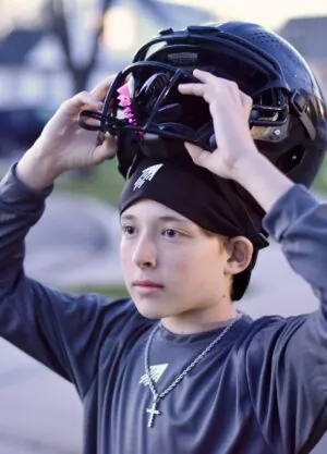 SpeedyPetey with the SPEEDY Performance Sport Beanie as he puts on his football helmet